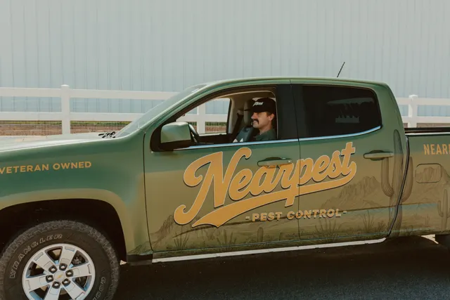 NEARPEST team member at the driver window of the branded pickup
